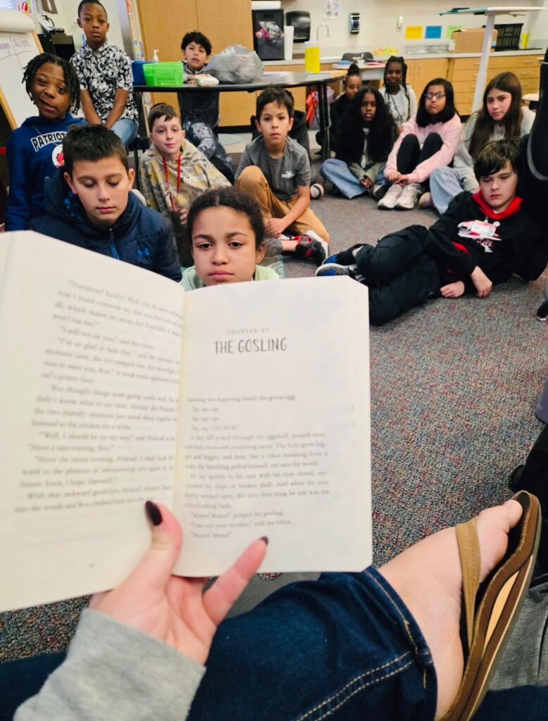teacher-holding-book-with-kids-in-background