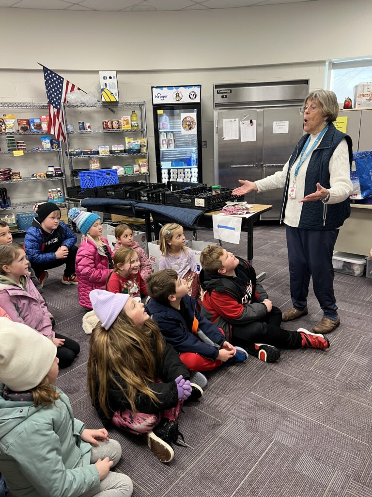 older-female-teacher-talking-to-young-students