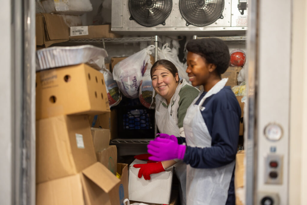 two-students-in-aprons-in-storage-closet